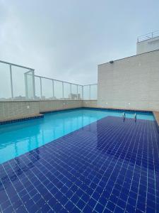 basen z niebieskimi płytkami na podłodze w obiekcie Lindo Studio em Vila Velha com vista para o mar w mieście Vila Velha