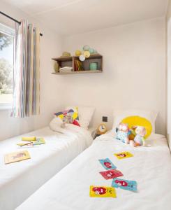 Duas camas com bichos de peluche num quarto em Chalet Hohllay em Reisdorf