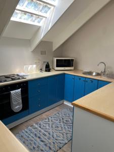 a kitchen with blue cabinets and a skylight at Constantia cottage- Warblers Nest in Cape Town +6 photos
