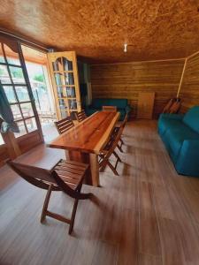 a room with a wooden table and chairs and a couch at Chalet de la Mare. in Salazie
