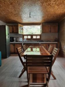 una cocina con mesa de madera y sillas. en Chalet de la Mare., en Salazie