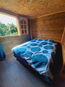 een slaapkamer met een bed in een kamer met een raam bij Chalet de la Mare. in Salazie