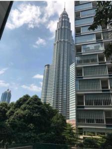 a tall building in front of a large building at Lovely 2&3bedrooms condo klcc and kL tower view in Kuala Lumpur