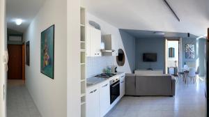 eine Küche mit weißen Schränken und ein Wohnzimmer in der Unterkunft Serendipity apartment in Venedig