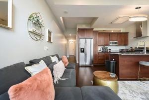 a living room with a couch and a kitchen at HostWise Stays - The Washington at Chatham - Park Free, Gym, More! in Pittsburgh