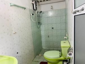La salle de bains est pourvue d'une douche et de toilettes vertes. dans l'établissement Sinharaja Tour Hostel, à Deniyaya