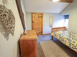 1 dormitorio con 1 cama y armario de madera en Ynys, en Dyffryn