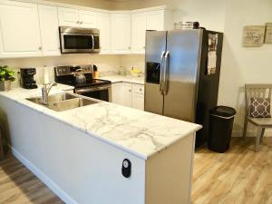 a kitchen with a stainless steel refrigerator and a sink at 17A GCR Lovely 2 bed Condo with pool in Surfside in Myrtle Beach
