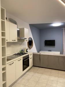 eine Küche mit weißen Schränken und einem TV an der Wand in der Unterkunft Serendipity apartment in Venedig + 13 Fotos
