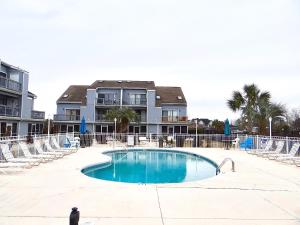 a swimming pool in front of a building at 17A GCR Lovely 2 bed Condo with pool in Surfside in Myrtle Beach
