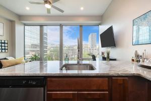 a kitchen with a sink and a large window at HostWise Stays - The Washington at Chatham - Free Garage Parking across from PPG Arena in Pittsburgh