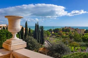 een terras met bomen en uitzicht op de oceaan bij La Paloma Blanca Hotel in Sciacca