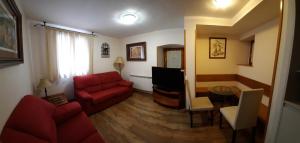 uma sala de estar com um sofá vermelho e uma televisão em Hotel Casa Escolano em El Pueyo de Jaca