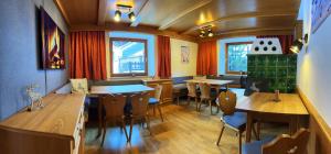 a restaurant with wooden tables and chairs and windows at Mountain Lodge Sölden - Ski in Bike out Chalet in Sölden