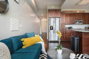 a living room with a blue couch and a kitchen at HostWise Stays - The Washington at Chatham - Free Parking, Great Views, Across from PPG Arena in Pittsburgh