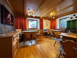 a dining room with tables and chairs and windows at Mountain Lodge Sölden - Ski in Bike out Chalet in Sölden