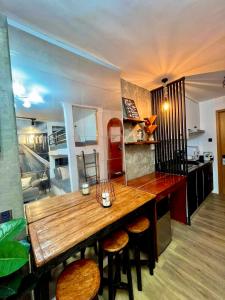 uma cozinha com uma grande mesa de madeira e bancos em Antara-QueenBed-Balcony-HotShower-WorkCoffee Station-FullKitchen em Talisay