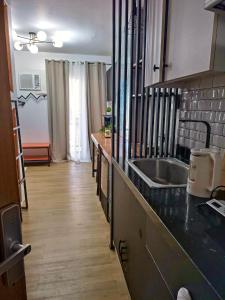 uma cozinha com um lavatório e uma bancada em Antara-QueenBed-Balcony-HotShower-WorkCoffee Station-FullKitchen em Talisay