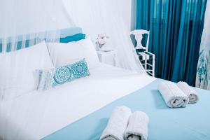 a bedroom with a white bed with towels on it at Villa Sea Breeze in Karpathos