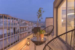 un balcón con 2 sillas y una mesa en un edificio en Luxury Apartment near Acropolis-Living Stone Gold, en Atenas