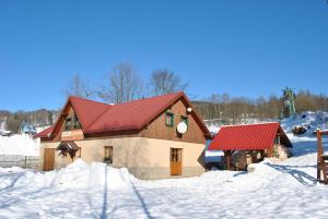a house with a red roof in the snow at Černý důl 18 in Černý Dŭl