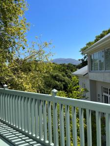 a white fence in front of a house at Constantia cottage- Warblers Nest in Cape Town
