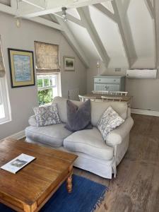 a living room with a couch and a coffee table at Constantia cottage- Warblers Nest in Cape Town