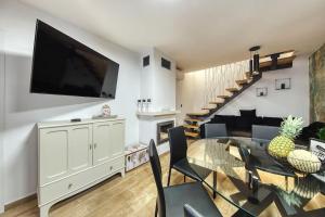 a living room with a table and a tv on a wall at Kuća za odmor Secret place in Lovinac