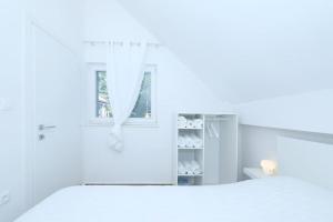 a white room with a window and a shelf at Kuća za odmor Secret place in Lovinac +11 photos