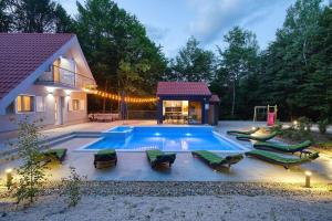 a swimming pool with lounge chairs and a house at Kuća za odmor Secret place in Lovinac