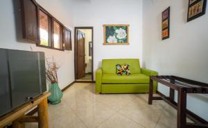 sala de estar con sofá verde y TV en LA GRANJA ECOHOTEL, en La Tebaida