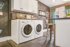 a laundry room with a washer and dryer at HostWise Stays - Chalk Art House - Chalkboard Wall, Private Parking, Patio in Pittsburgh