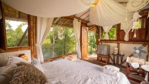 - une chambre avec un grand lit et une grande fenêtre dans l'établissement LA GRANJA ECOHOTEL, à La Tebaida