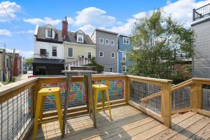 a balcony with yellow stools on a wooden deck at HostWise Stays - The Larryville - Amazing Bathroom, Perfect Location, Custom Build in Pittsburgh