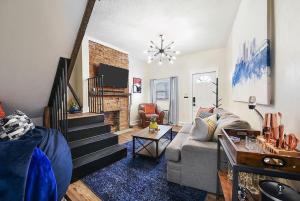 a living room with a couch and a staircase at HostWise Stays - The Larryville - Amazing Bathroom, Perfect Location, Custom Build in Pittsburgh