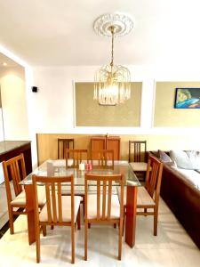 comedor con mesa, sillas y lámpara de araña en Guest ROOMS with living room, dining room and kitchen next to CENTER SOFIA en Sofía