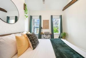 - une chambre avec un lit blanc et un miroir dans l'établissement HostWise Stays - The Larryville - Amazing Bathroom, Perfect Location, Custom Build, à Pittsburgh