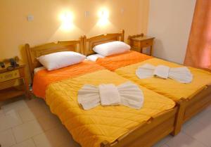 two beds with bow ties on them in a bedroom at Amaryllis Hotel in Karpathos