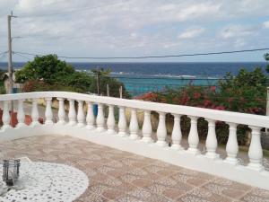 a white balcony with a view of the ocean at Tina's Guest House in Ocho Rios