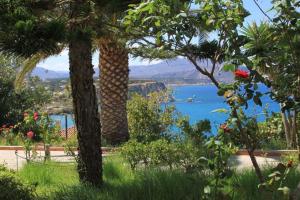 two palm trees with a view of the water at Villa Irini in Almyrida