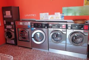 three washing machines are in a laundry room at B&B Pittoresco in Specchia