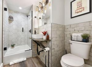 a bathroom with a toilet and a tub and a sink at HostWise Stays - The Grandview - Great City Views - Brand New Remodel in Pittsburgh +35 photos