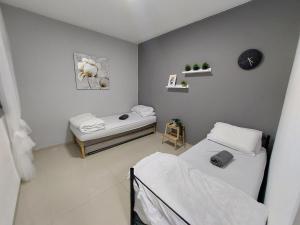 Habitación con 2 camas y reloj en la pared en אירוח ברמה אחרת, en Tiberíades
