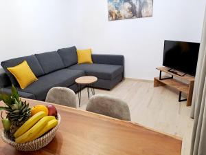 una sala de estar con sofá y un bol de fruta en Πλατανακι 1 Family Friendly, en Ándros