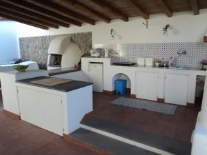 a large kitchen with white cabinets and a stove at Villa Valle Canale in Marina