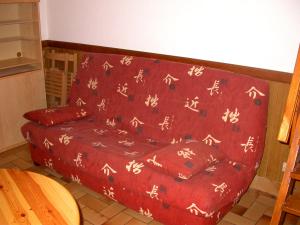 a red couch sitting in a living room at Appartement Résidence Napoléon in Cauterets