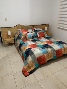a bed with a colorful quilt on it in a bedroom at Bellísimos apartamentos céntricos en La Mesa in La Mesa