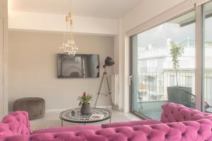 sala de estar con sofá rosa y mesa en Luxury Apartment near Acropolis-Living Stone Gold, en Atenas