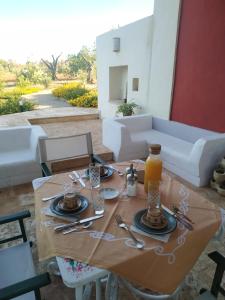 una mesa de madera con platos y utensilios. en Casina Rossa di Pietrafitta, en Casarano