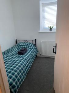a bedroom with a bed with a green plaid at Foxy cottage nr Westward Ho! in Northam